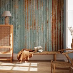 a room with a chair, table and lamp in front of an old rusty wall