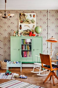 a green cabinet sitting in the middle of a living room next to a white chair