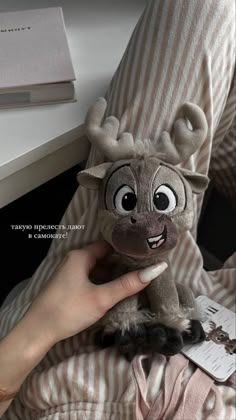 a person is holding a stuffed animal in their hand and it looks like they are wearing reindeer antlers