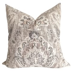 a decorative pillow with an intricate design on the front and back, in neutral tones