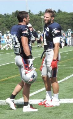 two football players are talking on the field