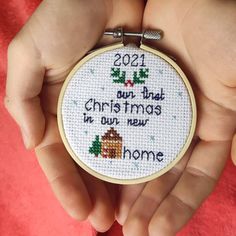 a person holding a cross stitch christmas ornament in their hands with the words,'2021 our that christmass in our new home '