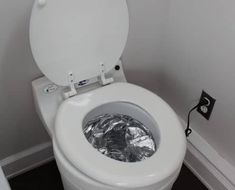 a white toilet sitting in a bathroom next to a wall