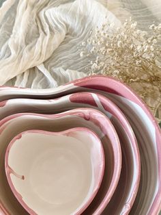 three pink and white bowls stacked on top of each other in the shape of a heart