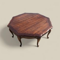 a wooden table with an oval shaped top and two legs on one end, in the shape of a hexagon