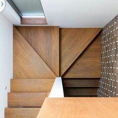 the interior of a modern house with wood and white accents on the walls, stairs and ceiling