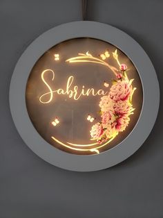 a neon sign that says sakina with flowers in the center on a gray wall