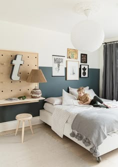 a young boy sitting on a bed in a bedroom