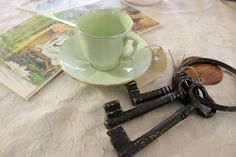 an old pair of scissors sits on a table next to a cup and saucer