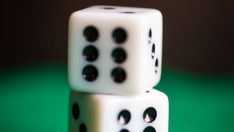 two white dices stacked on top of each other with one black dot in the middle