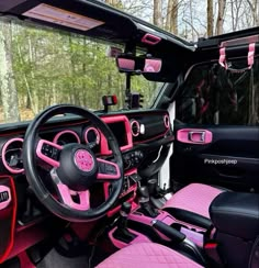 the interior of a pink and black jeep