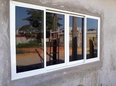 the reflection of a basketball hoop in an empty building's glass windows, as seen from outside