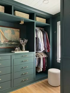 a walk in closet filled with lots of drawers and clothes on top of shelves next to a painting