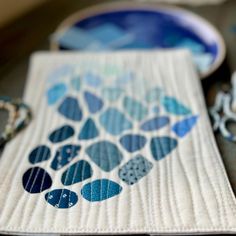 a blue and white piece of cloth with a chain on it sitting next to a plate