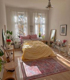 a bed sitting in a bedroom next to a window filled with lots of plants and furniture