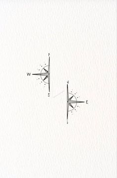 two compasss are drawn on paper with one pointing to the left and the other pointing up