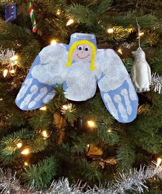 an angel ornament hanging on a christmas tree