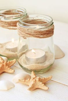 three mason jars filled with sand and starfish