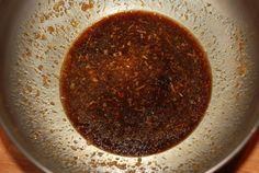 a sauce in a metal bowl on top of a wooden table