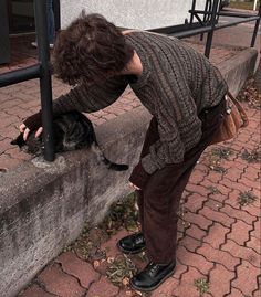 a woman is petting a cat on the street