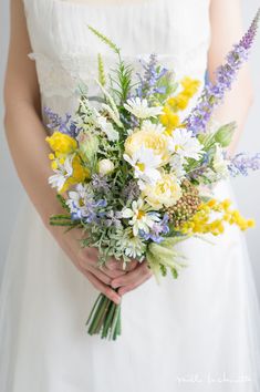 a woman holding a bouquet of flowers in her hands