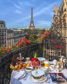 a table with food and drinks on it in front of the eiffel tower