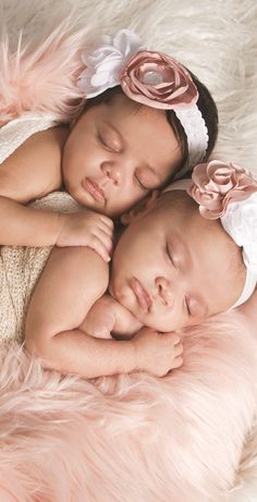 two baby girls sleeping on top of each other