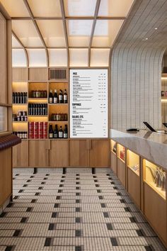 the interior of a restaurant with bottles and menus on the wall, along with black and white checkered tile flooring