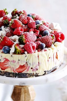 a cake topped with berries and whipped cream