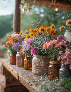 several mason jars filled with flowers sit on a table