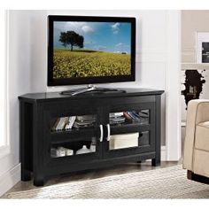 a flat screen tv sitting on top of a black entertainment center in a living room