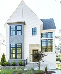 a large white house with lots of windows on it's front porch and stairs leading up to the second floor