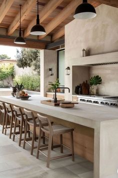 a large kitchen with an island counter and stools in front of the stove top