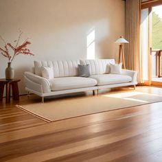 a white couch sitting on top of a hard wood floor