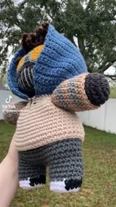 someone is holding up a crocheted stuffed animal