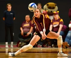 a female volleyball player is about to hit the ball with her racket while others watch