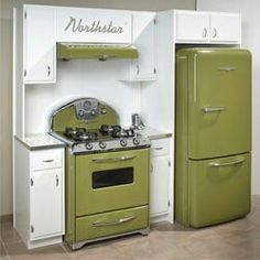 an old fashioned green stove and refrigerator in a kitchen