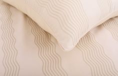 a close up view of a white pillow with wavy lines on the back and sides