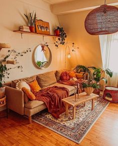 a living room filled with lots of furniture and plants on top of a wooden floor