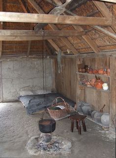 an old wooden hut with pots and pans on the shelves