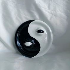 a black and white yin - yang sculpture sitting on top of a white cloth covered floor