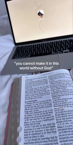 an open laptop computer sitting on top of a white bed next to a book with the words you cannot make it in this world without god