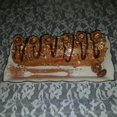 a piece of cake with chocolate drizzled on it sitting on a table