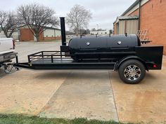 a black trailer parked in front of a brick building