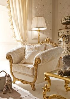 a teddy bear sitting on a chair in a room with white walls and gold trimmings