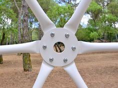 a close up of a white object in the middle of a park with many trees