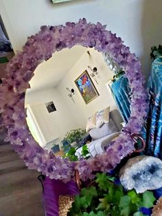 a mirror sitting on top of a table next to flowers and other things in front of it