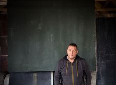 a man standing in front of a blackboard wearing a hoodie and sweatpants