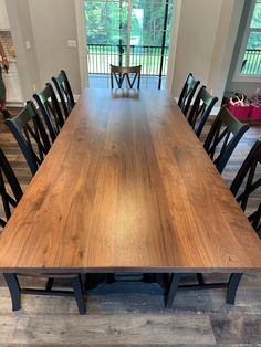 a large wooden table surrounded by black chairs