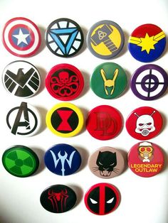 a bunch of avengers badges on a white surface